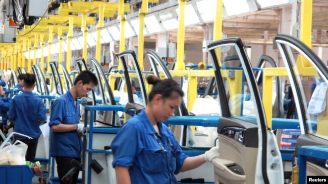 在中国广西壮族自治区柳州市的通用五菱汽车工，员工在一条生产线上工作(2016年6月19日) 