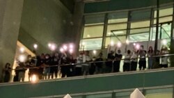 一批蘋果日報編採人員6月24日凌晨在蘋果日報大樓平台高舉手機燈，向大樓外聲援的市民表達謝意 (美國之音湯惠芸)