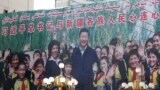 FILE - A propaganda poster showing Chinese President Xi Jinping with ethnic minority children and the slogan which reads "Party Secretary Xi Jinping and Xinjiang's multi ethnic residents united heart to heart" decorates the side of a building in Kashgar, 