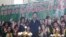 FILE - A propaganda poster showing Chinese President Xi Jinping with ethnic minority children and the slogan which reads "Party Secretary Xi Jinping and Xinjiang's multi ethnic residents united heart to heart" decorates the side of a building in Kashgar,