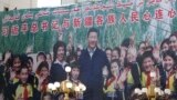 FILE - A propaganda poster showing Chinese President Xi Jinping with ethnic minority children and the slogan which reads "Party Secretary Xi Jinping and Xinjiang's multi ethnic residents united heart to heart" decorates the side of a building in Kashgar, 