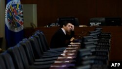 Un representante de Guatemala espera la llegada del canciller chileno Teodoro Ribera antes de una reunión en la sede de la OEA, en Washington DC, el 26 de noviembre de 2019.