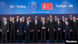 Turkish Prime Minister Ahmet Davutoglu (C) with European Union leaders during a EU-Turkey summit in Brussels, in March. A new EU plan will give Turkish citizens visa-free travel in the EU in exchange for the country's help in dealing with the migrant crisis.