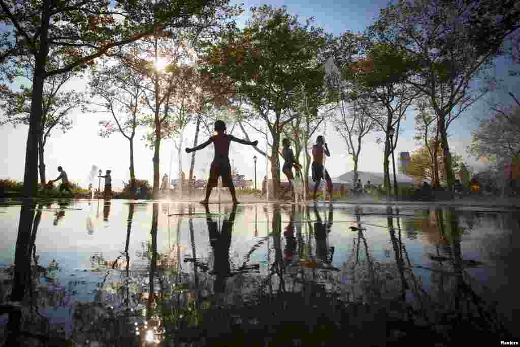 Anak-anak bermain di air mancur di distrik Manhattan bawah, New York.