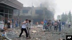 People carry injured people from one of explosion sites after several explosions killed at least 40 people and injured dozens in Reyhanli, near Turkey's border with Syria, May 11, 2013.