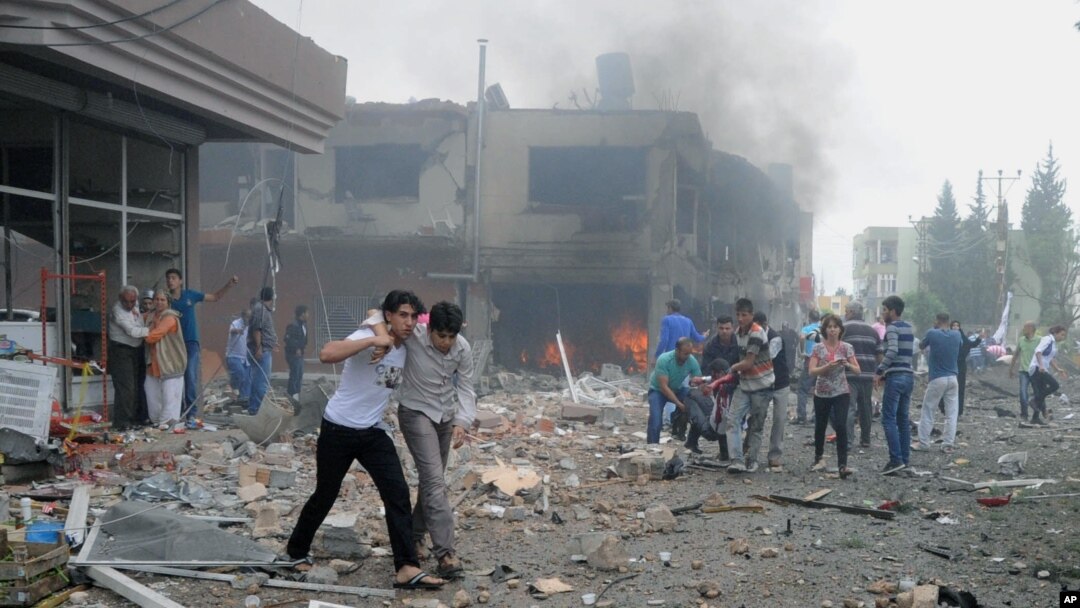 People carry injured people from one of explosion sites after several explosions killed at least 40 people and injured dozens in Reyhanli, near Turkey's border with Syria, May 11, 2013.