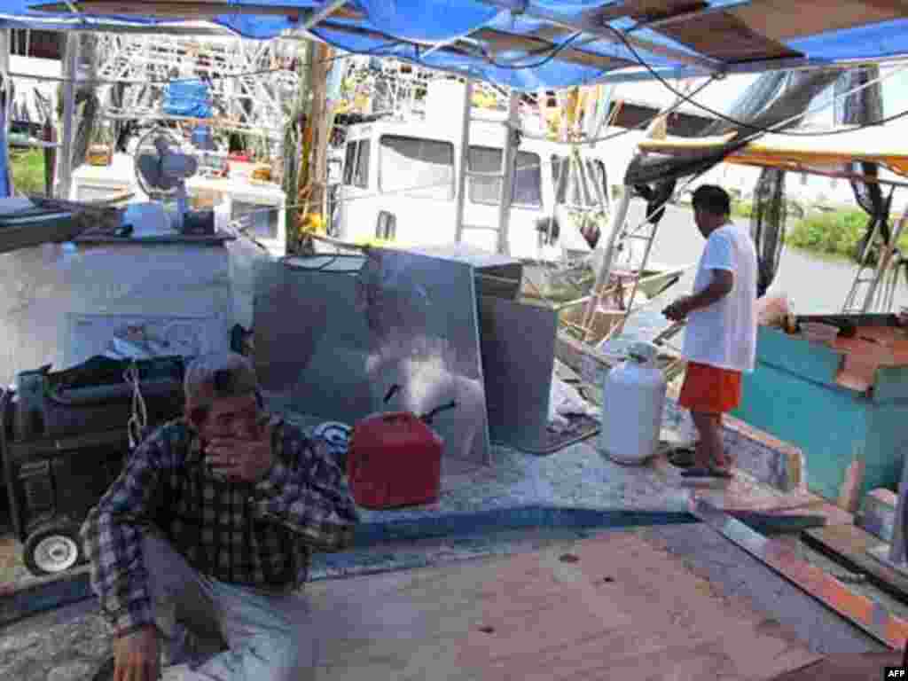 Fishermen repair their vessels while waiting for a job, Venice, New Orleans, 07/27/2010