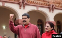 Venezuela's President Nicolas Maduro greets supporters with his wife Cilia Flores during an appearance at a military base in Caracas, Dec. 8, 2016.