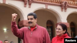 FILE - Venezuela's President Nicolas Maduro greets supporters with his wife Cilia Flores during an appearance at a military base in Caracas, Dec. 8, 2016.