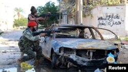 Pro-government Libyan forces aim their weapons during clashes with the Shura Council of Libyan Revolutionaries, an alliance of former anti-Gadhafi rebels, who have joined forces with the Islamist group Ansar al-Sharia, in Benghazi, December 28, 2014.