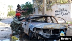 Tentara Libya pro-pemerintah mengarahkan senjatanya dalam bentrokan dengan pemberontak di Benghazi, Desember 2014.