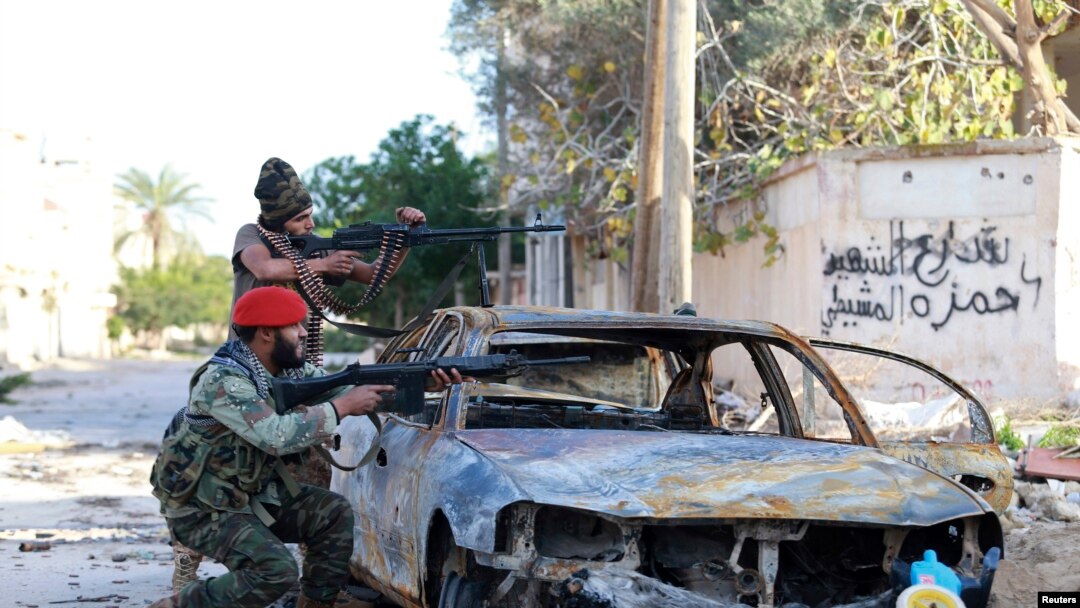Pasukan pro-pemerintah Libya membidik senjata mereka dalam bentrokan dengan Dewan Shura Revolusioner Libya, aliansi man tan pemberontak anti-Gadhafi, yang bergabung dengan kelompok Islamis Ansar al-Sharia, di Benghazi, 28 Desember 2014.