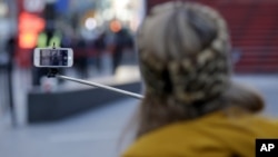 Selfie ရိုက်နေသူတစ်ဦး။ ( ၂၀၁၅၊ Times Square၊ နယူးယောက်) 