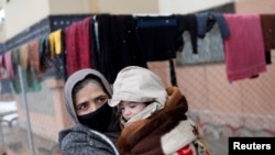 Baby Sohail Ahmadi is carried by his grandmother as they leave then house of Hamid Safi, a 29-year-old taxi driver who found Sohail in the airport, in Kabul, Afghanistan, Jan. 8, 2022.