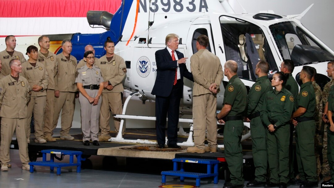Presiden AS Donald Trump berbincang dengan petugas perbatasan saat mengunjungi Fasilitas Perbatasan di Yuma, negara bagian Arizona, Selasa (22/8). 