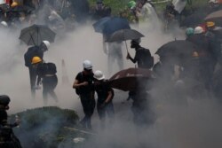 Anti-extradition bill protesters are surrounded by tear gas during clashes with police in Tsuen Wan in Hong Kong, Aug. 25, 2019.