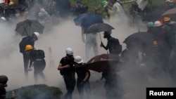 Anti-extradition bill protesters are surrounded by tear gas during clashes with police in Tsuen Wan in Hong Kong, Aug. 25, 2019. 