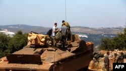 Tentara Israel berdiri di atas Namer IFV (Infantry Fighting Vehicle) di dekat kota Avivim, Israel utara di sepanjang perbatasan dengan Lebanon, 23 Juli 2020. (Foto oleh JALAA MAREY / AFP)