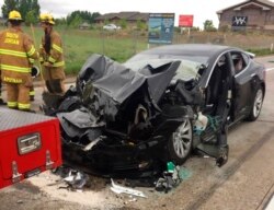 FILE - This photo released by the South Jordan Police Department shows a traffic collision involving a Tesla Model S sedan with a fire department mechanic truck stopped at a red light in South Jordan, Utah, May 11, 2018.