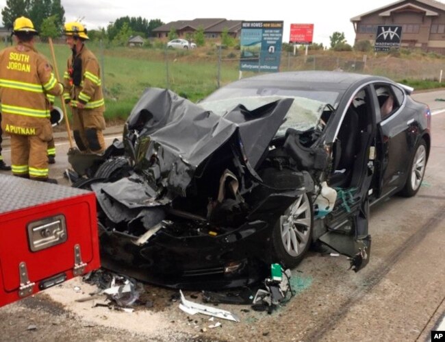 FILE - This photo released by the South Jordan Police Department shows a traffic collision involving a Tesla Model S sedan with a fire department mechanic truck stopped at a red light in South Jordan, Utah, May 11, 2018.