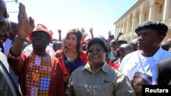 Morgan Tsvangirai, à gauche, chef du mouvement pour le changement démocratique du Zimbabwe (MDC), fait un geste à côté du leader du Zimbabwe People (ZIMPF), Joice Mujuru, ancien vice-président du Zimbabwe, lors d'une marche contre la mauvaise manipulation de l'économie par le gouvernement du président Robert Mugabe à Gweru, le 13 août 2016. 