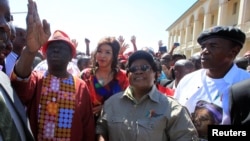 FILE - Morgan Tsvangirai, left, leader of Zimbabwe's main opposition Movement For Democratic Change, gestures next to Zimbabwe People Firstleader Joice Mujuru, center, who is a former Vice President of Zimbabwe, during a march against what protesters say is the mishandling of the economy by President Robert Mugabe's government in Gweru, Aug. 13, 2016. 