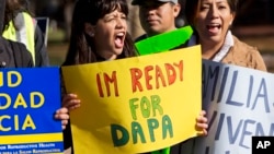 Danna Chavez Calvi, 23, (left) and a young woman who requested not to be named, participate in a rally for immigration reform after marching from Arlington, Va., to the White House in Washington, Nov. 20, 2015.