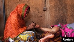 Une femme nigérienne tatoue les pieds dans son studio à Niamey, le 20 September 2013.