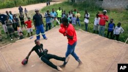 FILE - In this Feb. 12, 2017 photo, a young boy is knocked out during a boxing match in Chitungwiza, Zimbabwe.