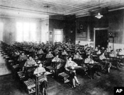 The women sit at their desks where they painted the watch faces, at the Radium Dial plant in Ottawa, Illinois, 1924.