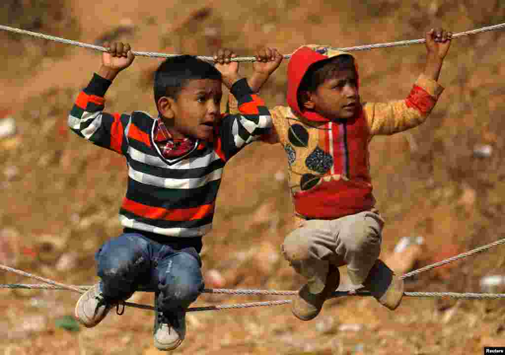 Children wait to observe the bull fight during the Maghesangranti festival, which commemorates the start of the holy month of Magh, ushering in the coming of warmer weather and longer days, at Talukachandani village in Nuwakot district near Kathmandu, Nepal.