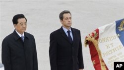 French President Nicolas Sarkozy, right, and Chinese President Hu Jintao, salute the French flag, shortly after the arrival of Hu Jintao at Paris Orly airport Thursday Nov. 4, 2010. Chinese President Hu Jintao is on a two-day state visit in France.(AP Pho