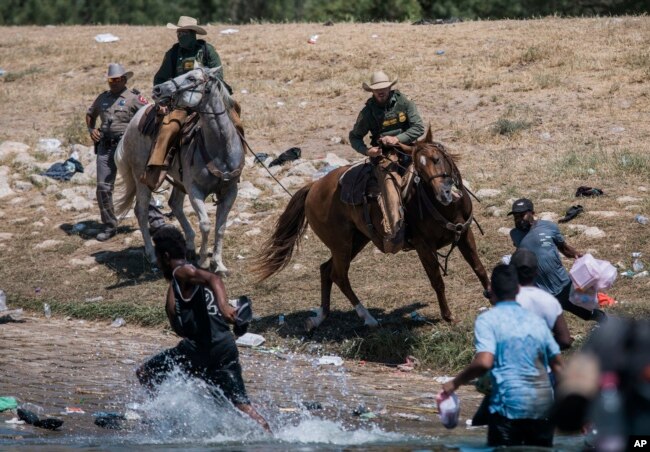 Inmigrantes haitianos son impedidos de cruzar hacia la parte estadounidense en Del Río, Texas.