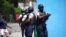 Police officers with their weapons drawn search for suspects in the killing of Haiti's President Jovenel Moise, in Port-au-Prince, Haiti, July 8, 2021.