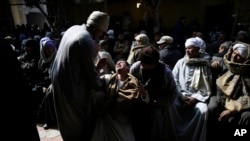 Des hommes assistent à un deuil au sein de la communauté copte d’Egypte, au Caire, Egypte, 16 février 2015.