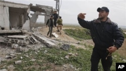 A Palestinian Hamas member inspects the damage after an Israeli strike in east of Gaza strip, March 19, 2011