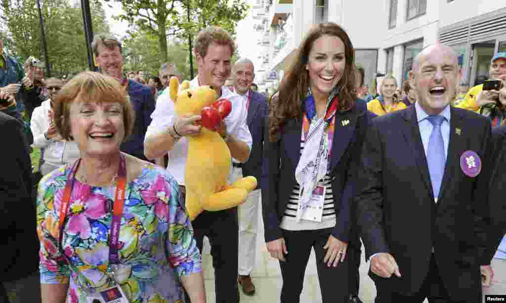 Britain's Prince Harry (2nd L) holds a kangaroo mascot given by Australian athletes next to MP Tessa Jowell (L), Catherine, Duchess of Cambridge and Mayor of the Olympic Village Sir Charles Allen (R), during a visit to the accommodation for British athlet