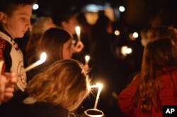 Aztec High School students and area residents gather for a candlelight vigil in Aztec, N.M., Thursday, Dec. 7, 2017, after a shooting at the high school.