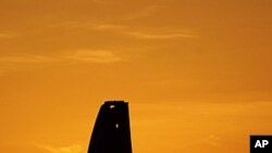 An oil pump works at sunset in the desert oil fields of Sakhir, Bahrain, in the Persian Gulf. Iran test-fired a surface-to-surface cruise missile Monday in a drill its navy chief said proved Tehran was in complete control of the strategic Strait of Hormuz