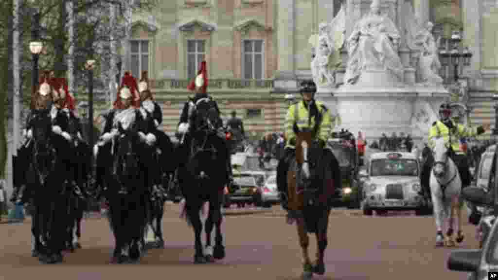 Backdropped by Buckingham Palace, Queen's Life Guards and police offcers ride down the Mall in London where the finish area of the forthcoming London Marathon.
