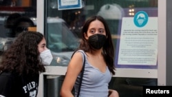 People wear masks against COVID-19. The CDC now suggests that vaccinated people wear masks. The Delta variant spreads quickly and has led to a surge in infections in the U.S. (REUTERS/Brendan McDermid)