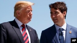 FILE - President Donald Trump talks with Canadian Prime Minister Justin Trudeau during a G-7 Summit welcome ceremony.