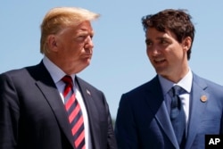 FILE - President Donald Trump talks with Canadian Prime Minister Justin Trudeau during a G-7 Summit welcome ceremony.