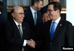 U.S. Secretary of the Treasury Steven Mnuchin and Brazil's Finance Minister Henrique Meirelles shake hands after posing for the official photo at the G20 Meeting of Finance Ministers in Buenos Aires, Argentina, March 19, 2018.