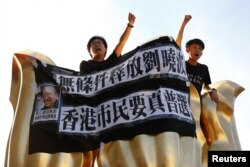 Pro-democracy activists chant slogans on the Golden Bauhinia Square, a gift from China at the 1997 handover, during a protest a day before Chinese President Xi Jinping is due to arrive for the celebrations, in Hong Kong, China, June 28, 2017.