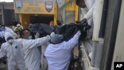 Forensic workers load into a truck bodies of inmates killed during a fire inside the prison in Comayagua, Honduras, Feb. 15, 2012.