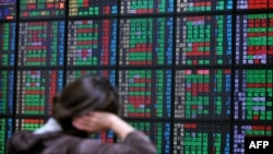 Seorang investor mengawasi pergerakan pasar saham di sebuah perusahaan sekuritas di Taipei (16/4). (AFP/Mandy Cheng)