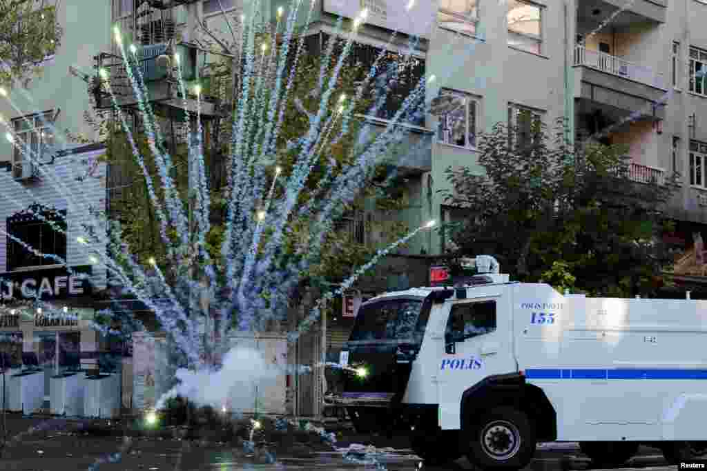 Polisi anti huru-hara menggunakan meriam air saat demonstran melemparkan kembang api ketika berdemo menentang jam malam di distrik Sur, di kota tenggara Diyarbakir, Turki, yang didominasi Kurdi.