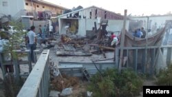 Abanyagihugu bariko baraba ivyononwe na bombe yaguye kw'ikambi y'abateshejwe ingo zabo mu mirwanyo yahuje imihari yitwaje ibirwanisho iTripoli, muri Libiya, itariki 2/9/2018.