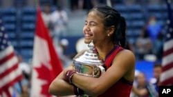 Emma Raducanu, of Britain, hugs the US Open championship trophy after defeating Leylah Fernandez, of Canada, during the women's singles final of the US Open tennis championships, Saturday, Sept. 11, 2021, in New York.